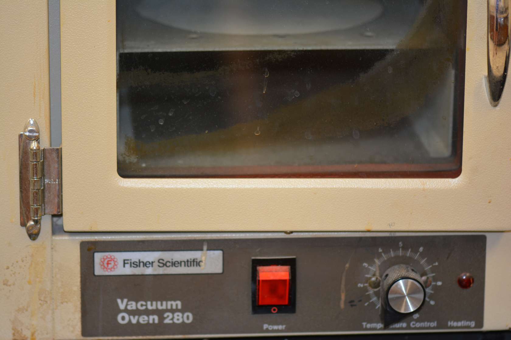 The Fisher Scientific Isotemp 280A Vacuum Oven offers a temperature range from ambient up to 200°C with internal dimensions of 11.125"D x 9.75"W x 9.75"H. Front-mounted power indicator and dial thermometer with top-mounted analog vacuum gauge. The 280A's hydraulic thermostat controls temperature. Large glass panel front door and stainless steel chamber.